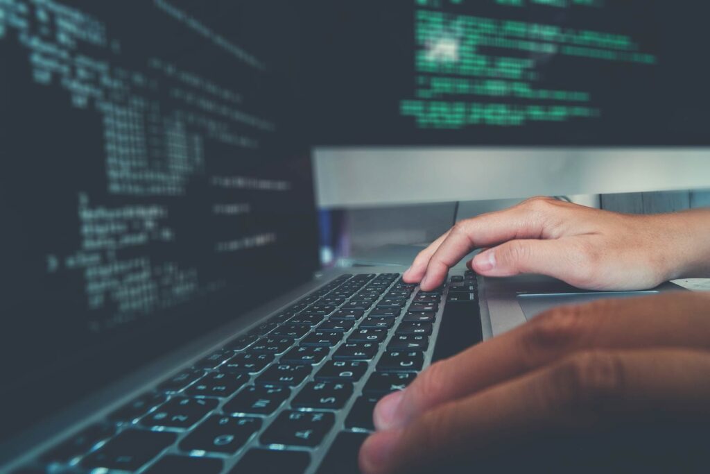 Hands typing on a laptop with code on screen, representing responsive web design work in London.