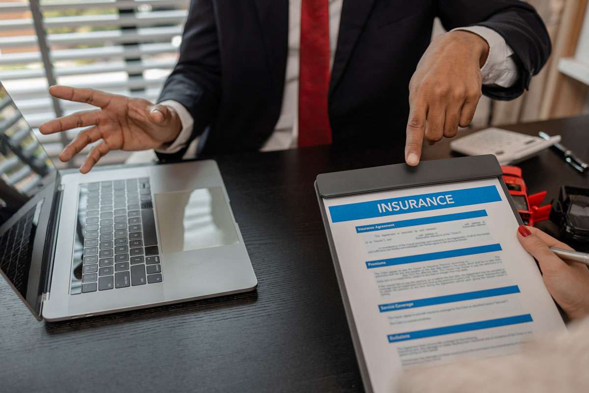 Business meeting on SEO for insurance companies, with a focus on digital strategies, showing insurance documents on a tablet.