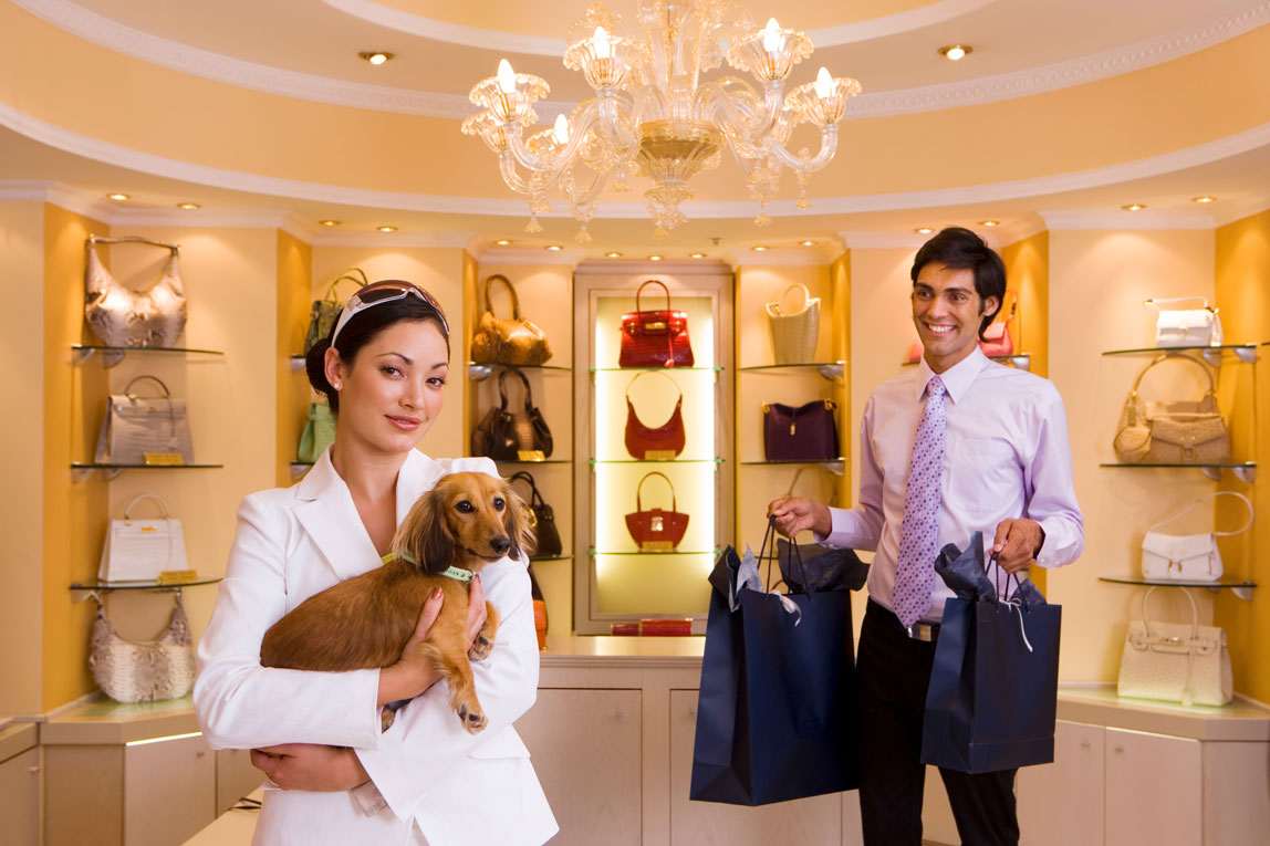 Luxury boutique with a woman holding a dog and a man carrying shopping bags, highlighting SEO for luxury brands.